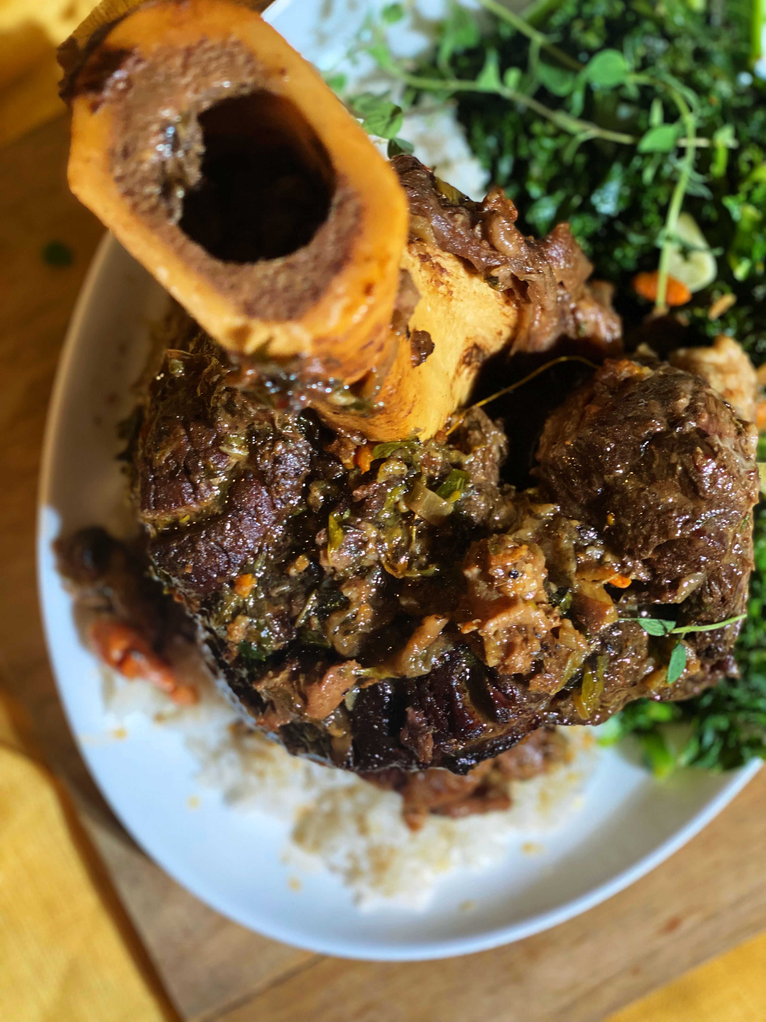 overhead shot of the cooked and plated beef shank set over white rice and sauteed kale