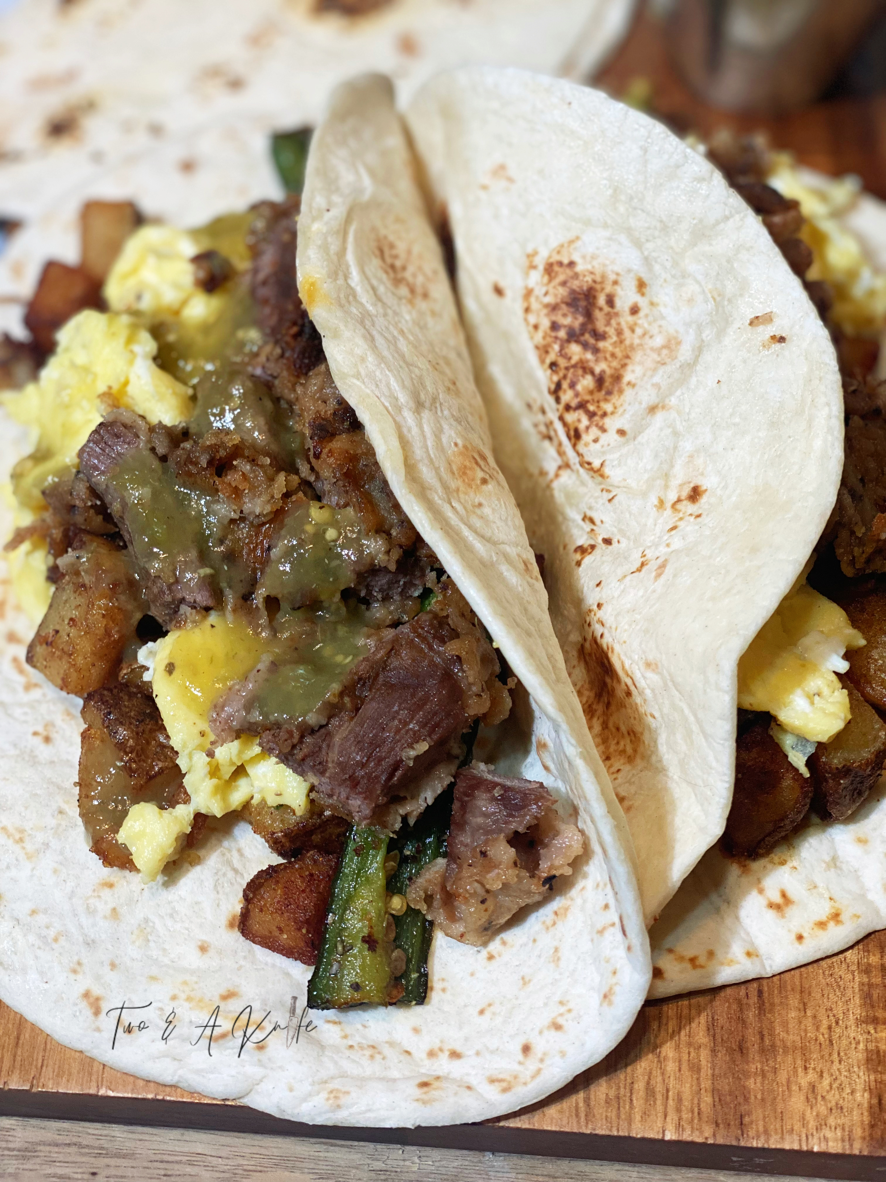 overhead shot of the plated chicken fried chicken breakfast taco, green sauce, potato and egg